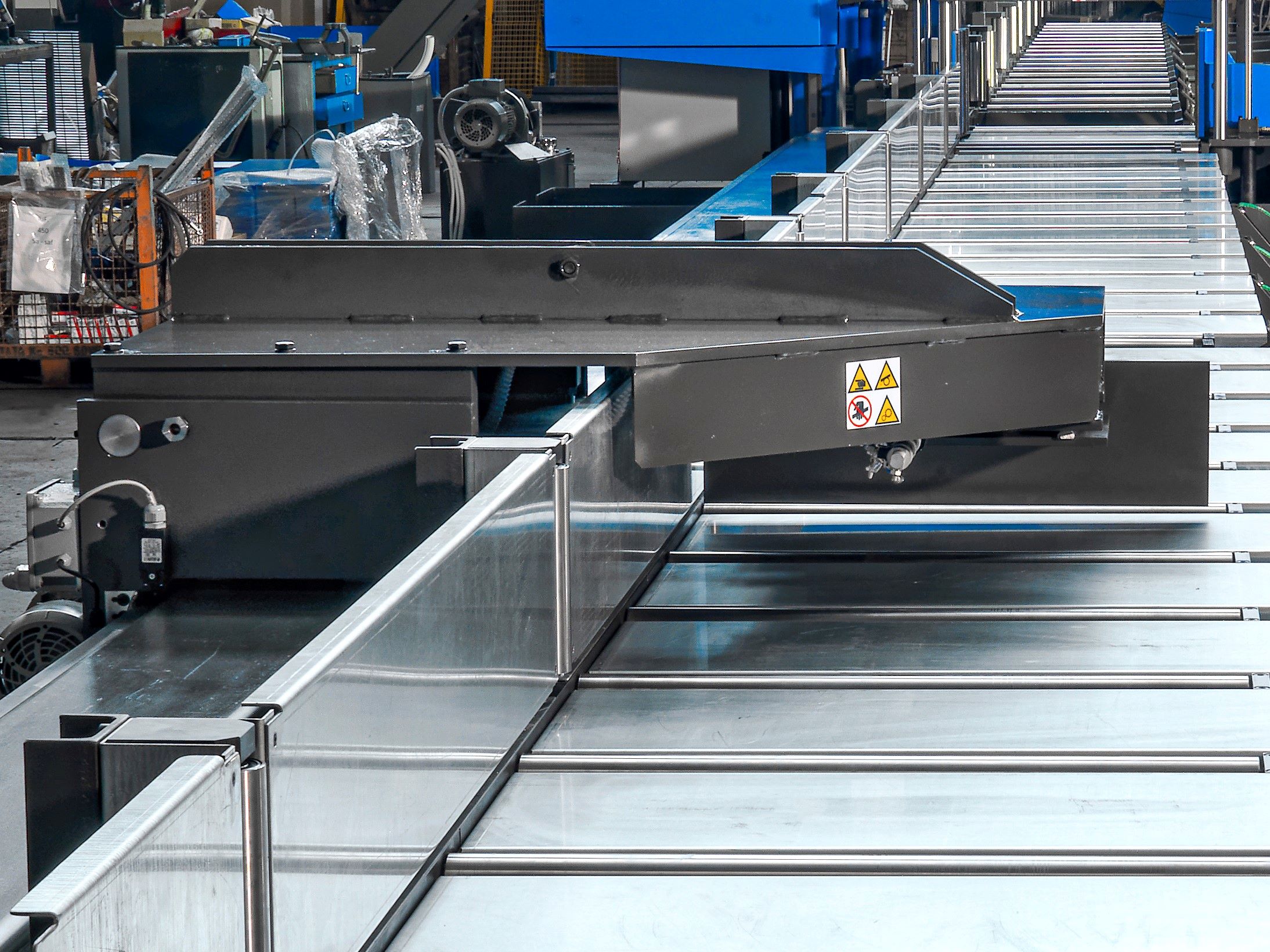 Powered length stop mounted on iron pipe with hydraulic lifting system for precise automated positioning and cutting.